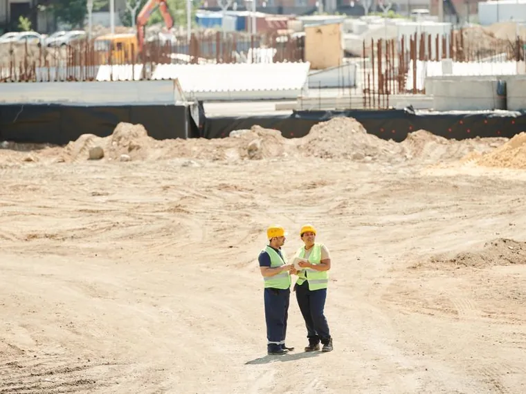 Two engineers reviewing plans on a construction site